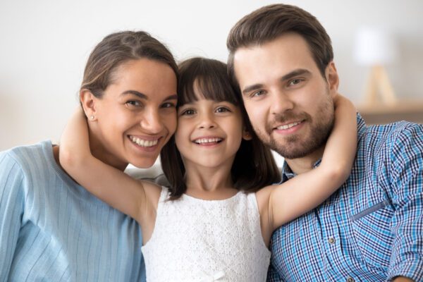 Portrait happy family posing looking at camera Happy Adoptive Family Smiling Together